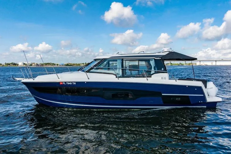 Slide: The Image of 2023 Jeanneau NC 1095 boat on calm water under a blue sky. - 3