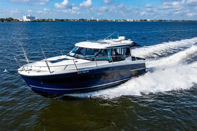 Slide: The Image of 2023 Jeanneau NC 1095 cruising on open water under a clear blue sky. - 4