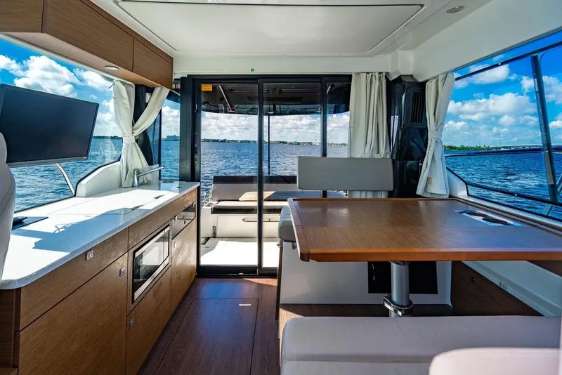 Slide: The Image of Interior of 2023 Jeanneau NC 1095 yacht with modern kitchen and dining area, overlooking the water. - 41