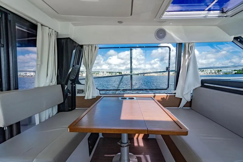 Slide: The Image of Interior of 2023 Jeanneau NC 1095 boat with scenic water view through windows. - 42
