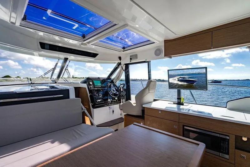 Slide: The Image of Interior of 2023 Jeanneau NC 1095 boat with modern helm and panoramic windows. - 45