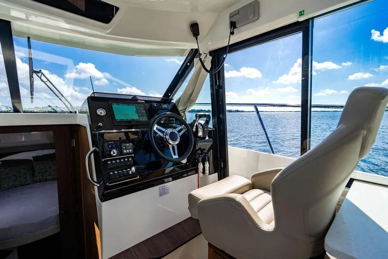 Slide: The Image of Interior helm of 2023 Jeanneau NC 1095 boat with modern controls and ocean view. - 46