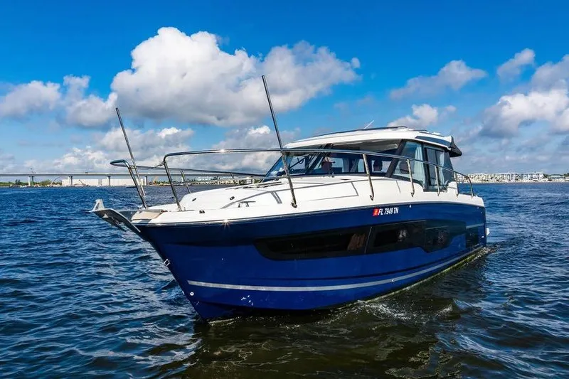 Slide: The Image of 2023 Jeanneau NC 1095 boat cruising on open water under a blue sky. - 5