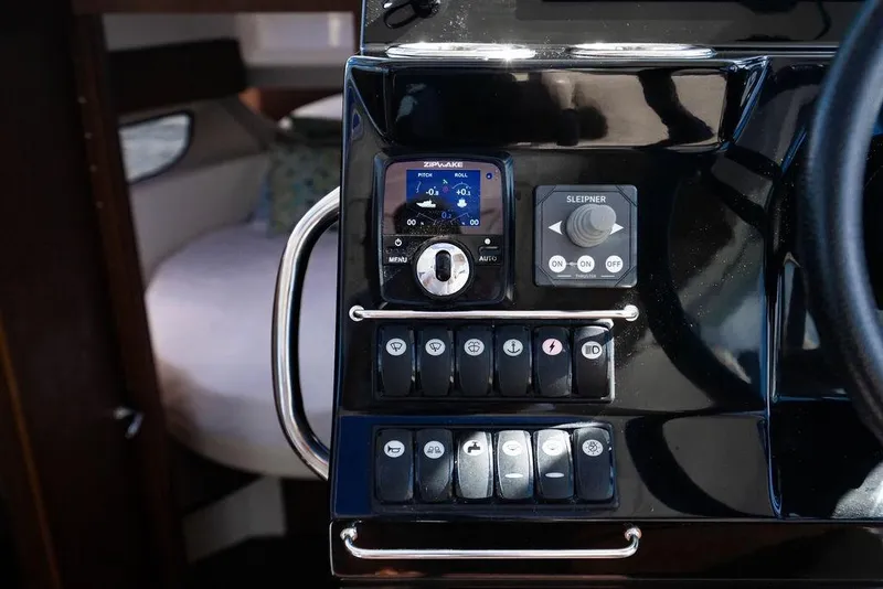 Slide: The Image of Control panel of 2023 Jeanneau NC 1095 boat with navigation and control switches. - 52