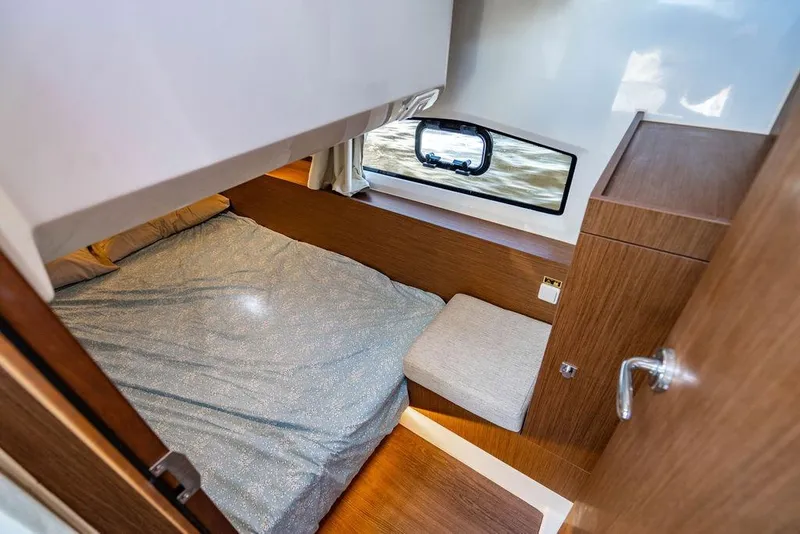 Slide: The Image of Cozy cabin interior of 2023 Jeanneau NC 1095 with bed and window view. - 57