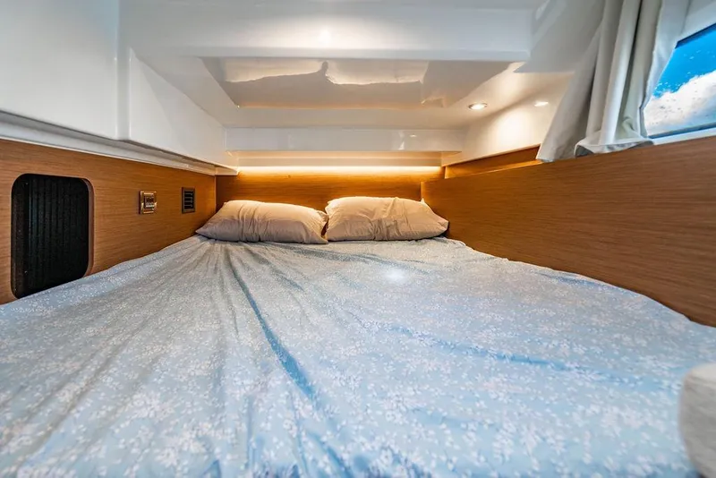 Slide: The Image of Cozy cabin interior of 2023 Jeanneau NC 1095 with comfortable bedding and ambient lighting. - 58