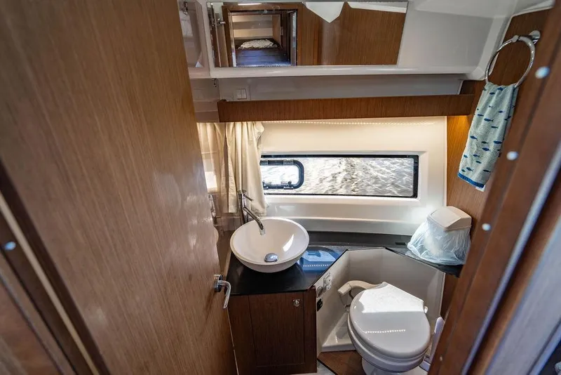 Slide: The Image of 2023 Jeanneau NC 1095 boat bathroom with sink, toilet, and window view. - 60
