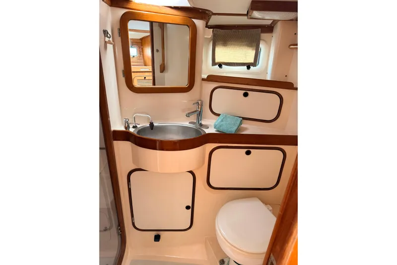 Slide: The Image of Compact bathroom in 1987 Norseman 400 yacht with sink, mirror, and storage cabinets. - 53