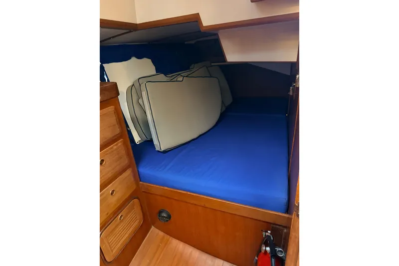 Slide: The Image of Cozy cabin interior of 1987 Norseman 400 sailboat with blue bedding and wooden storage. - 77