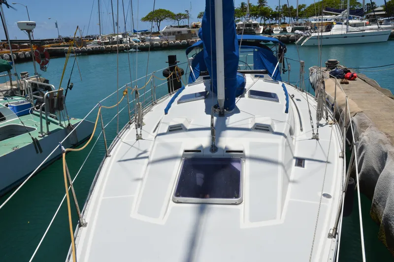 Slide: The Image of 1987 Norseman 400 sailboat docked in a sunny marina, surrounded by other boats. - 12