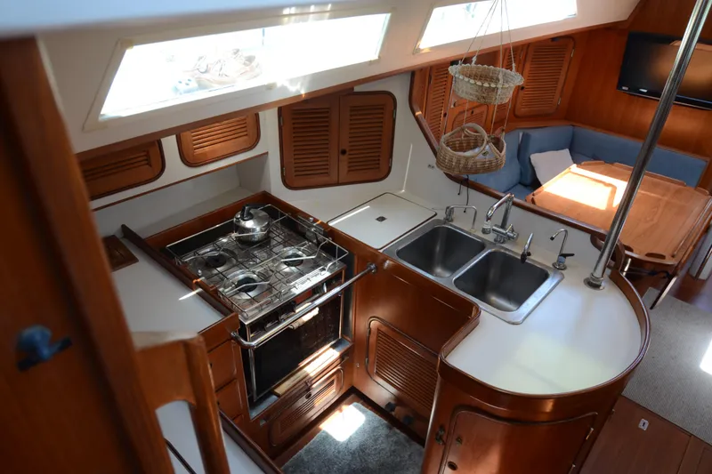 Slide: The Image of Interior of 1987 Norseman 400 yacht featuring kitchen and dining area with wooden cabinetry. - 22