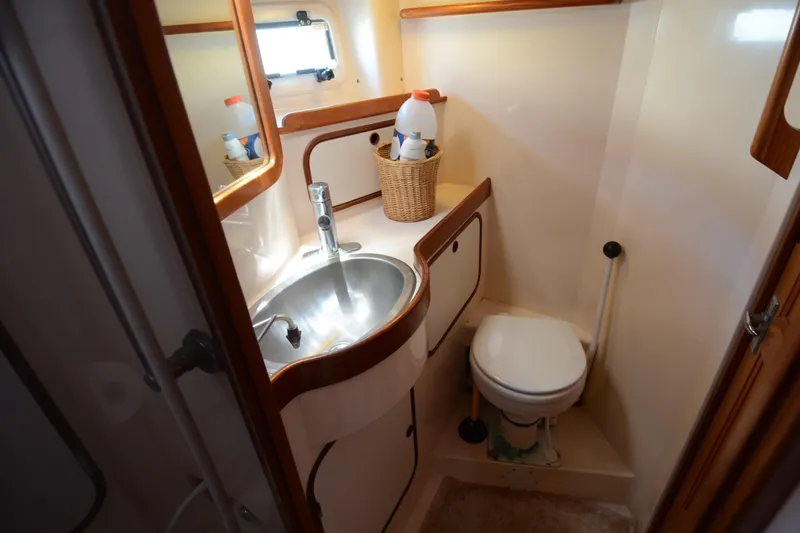 Slide: The Image of Compact bathroom in 1987 Norseman 400 yacht with sink, toilet, and storage basket. - 27
