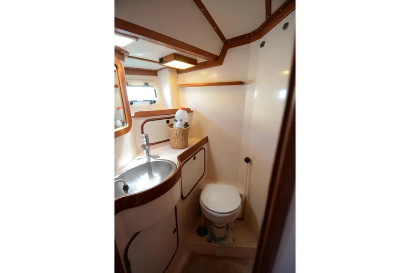 Slide: The Image of Compact bathroom in 1987 Norseman 400 yacht, featuring sink, toilet, and wooden accents. - 29