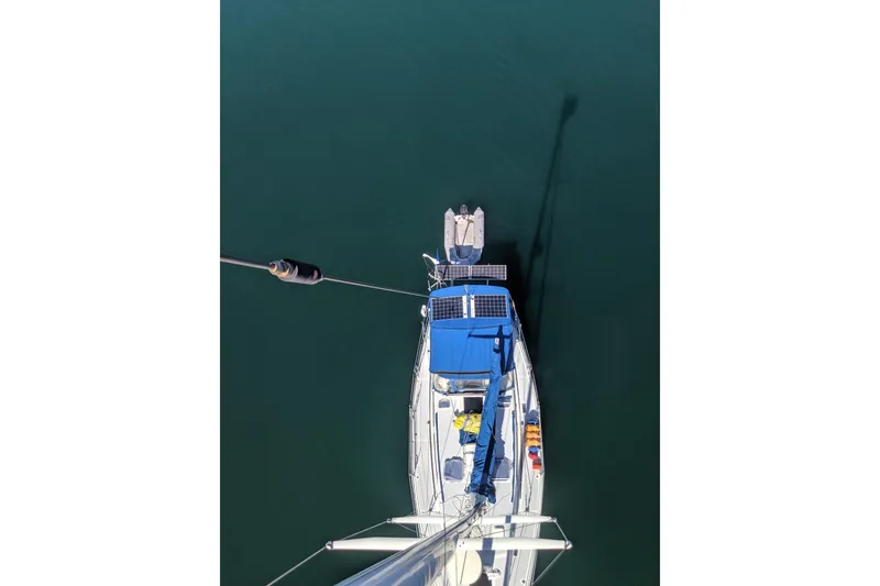 Slide: The Image of Aerial view of 1987 Norseman 400 sailboat with solar panels and dinghy on calm water. - 3