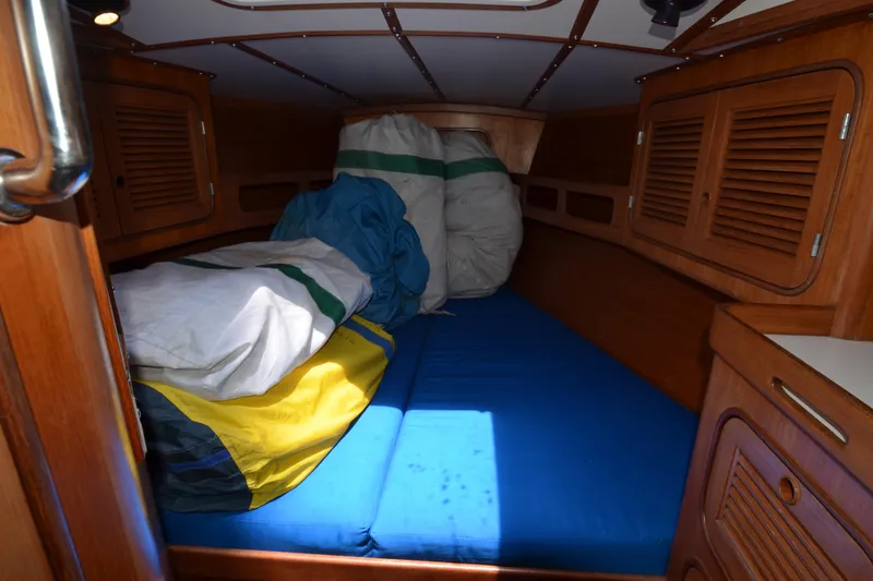 Slide: The Image of Cozy cabin interior of 1987 Norseman 400 sailboat with wooden finish and colorful sails. - 30