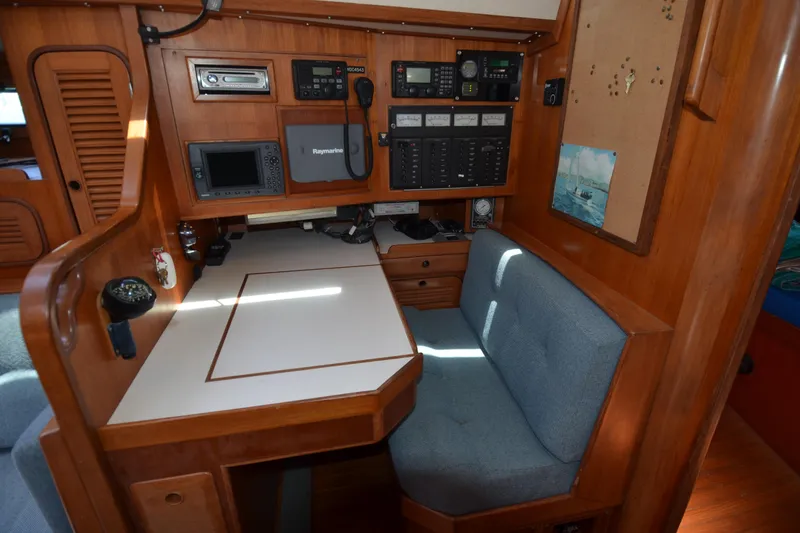 Slide: The Image of Navigation station inside 1987 Norseman 400 sailboat with control panels and seating. - 35