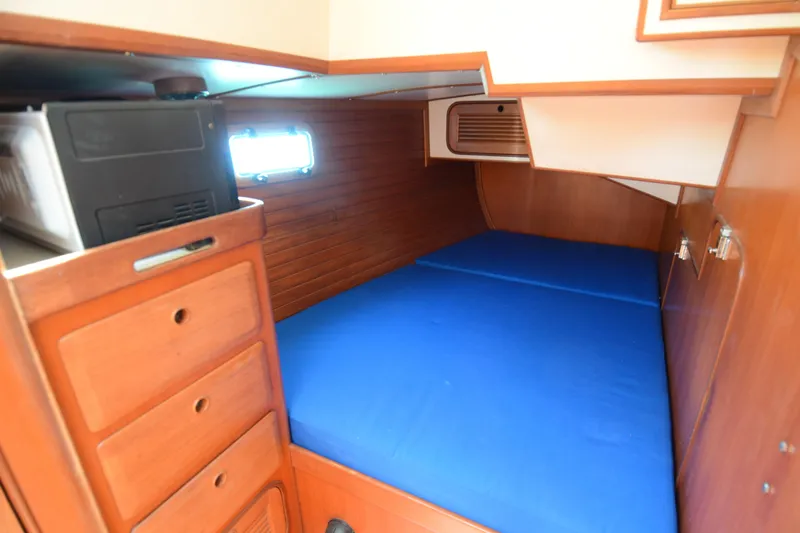 Slide: The Image of Cozy cabin interior of 1987 Norseman 400 sailboat with blue bedding and wooden storage. - 36