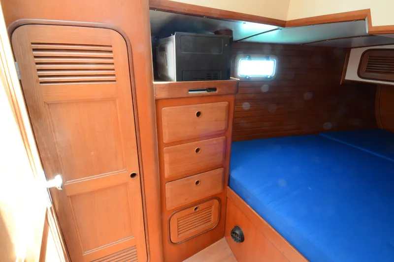 Slide: The Image of Interior of 1987 Norseman 400 yacht with wooden cabinetry and blue bedding. - 37