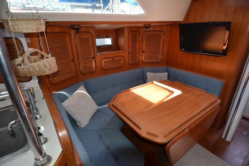 Slide: The Image of Cozy interior of 1987 Norseman 400 sailboat with wooden dining area and blue seating. - 38