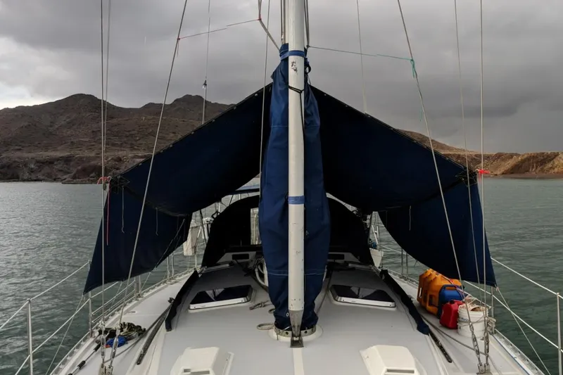 Slide: The Image of 1987 Norseman 400 sailboat on water, cloudy sky, rocky shoreline in background. - 40