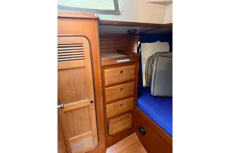 Slide: The Image of Interior of 1987 Norseman 400 sailboat with wooden cabinetry and blue cushions. - 76