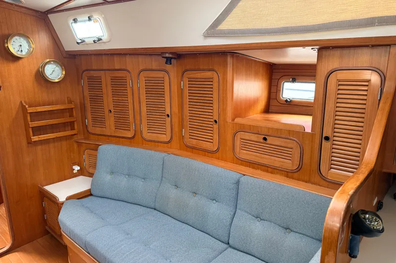 Slide: The Image of Interior of 1987 Norseman 400 sailboat with wooden cabinetry and blue cushioned seating. - 45