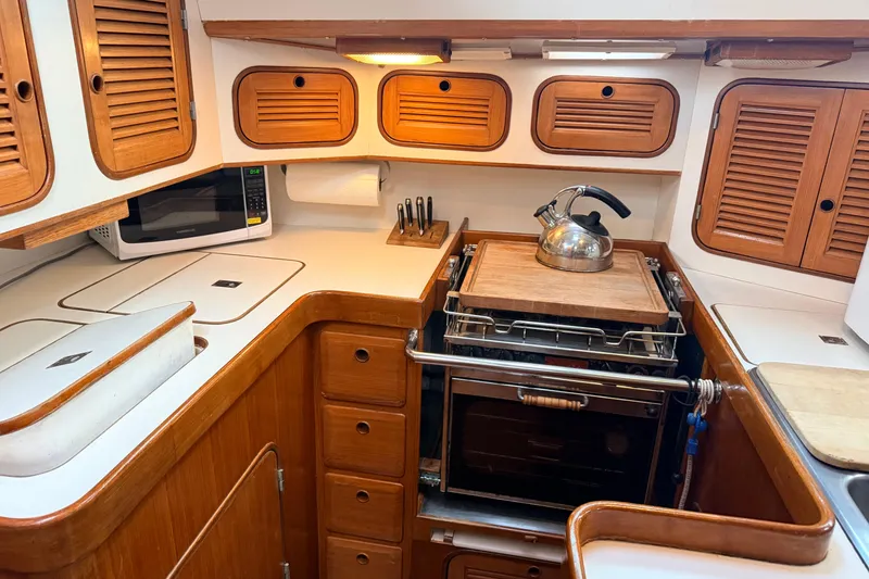 Slide: The Image of Compact kitchen in 1987 Norseman 400 yacht with wooden cabinets and modern appliances. - 36