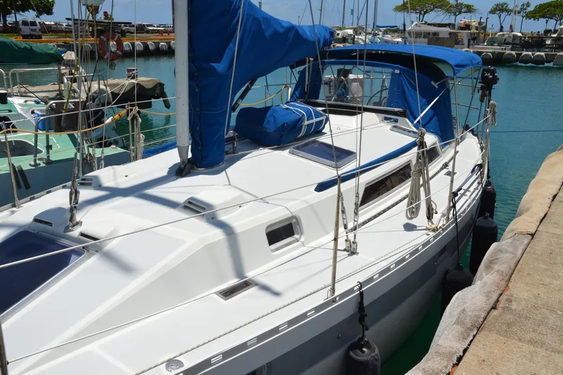 Slide: The Image of 1987 Norseman 400 sailboat docked in a marina, featuring blue covers and clear skies. - 9