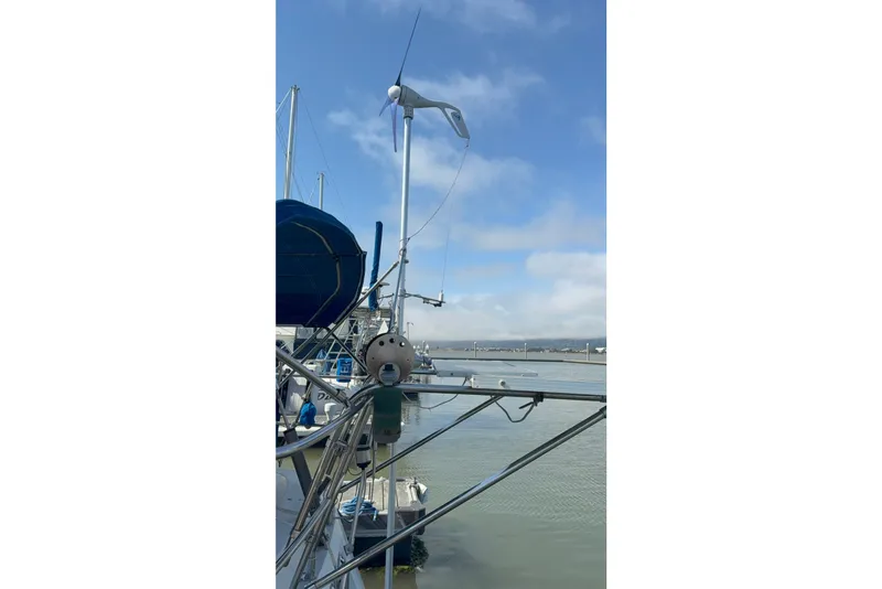 Slide: The Image of Sailboat Norseman 400, 1987 model, docked with wind turbine against blue sky. - 17