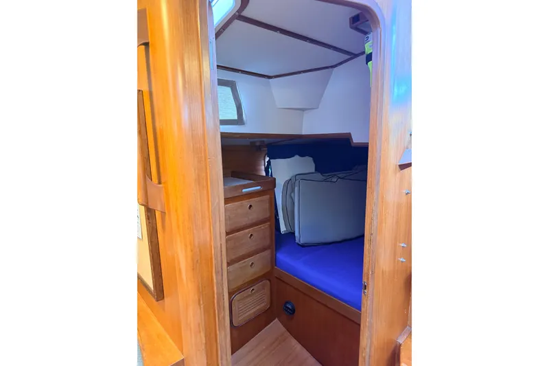 Slide: The Image of Cozy cabin interior of 1987 Norseman 400 sailboat with wooden drawers and blue bedding. - 75