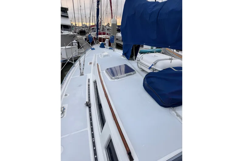 Slide: The Image of 1987 Norseman 400 sailboat deck with blue covers, docked in a marina. - 19