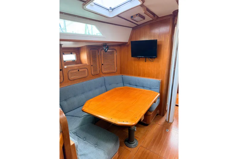 Slide: The Image of Interior of 1987 Norseman 400 sailboat with wooden dining area and cushioned seating. - 46