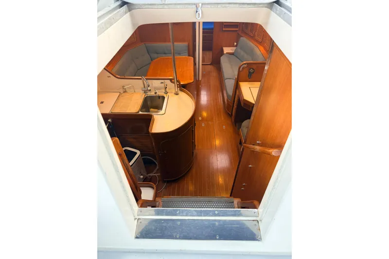 Slide: The Image of Interior view of 1987 Norseman 400 sailboat, featuring wooden cabinetry and seating area. - 32