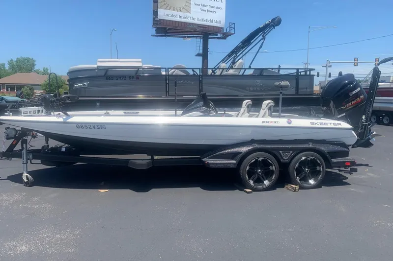 The Image of 2020 Skeeter FXR21 boat on trailer, parked outdoors, featuring sleek design and Yamaha engine. - 1