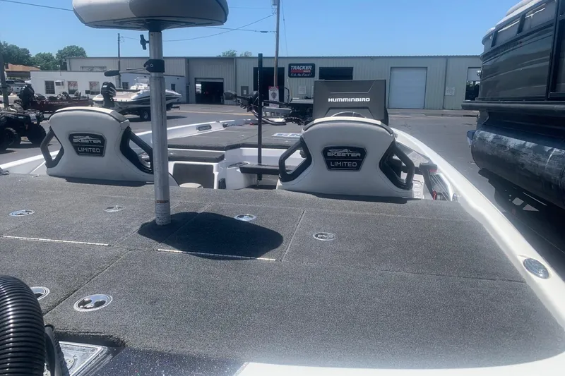 Slide: The Image of 2020 Skeeter FXR21 boat interior with seats and fishing equipment, parked outdoors. - 8