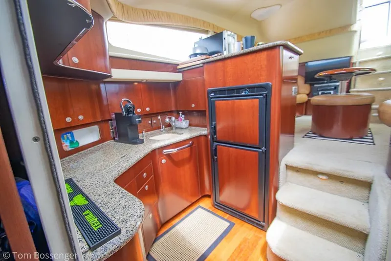 Slide: The Image of Luxurious 2005 Sea Ray 390 Motor Yacht interior with modern kitchen and elegant wood finishes. - 19
