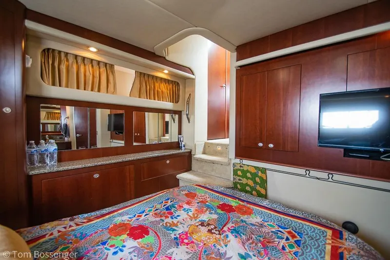 Slide: The Image of Luxurious 2005 Sea Ray 390 Motor Yacht interior with vibrant bedding and elegant wood cabinetry. - 31