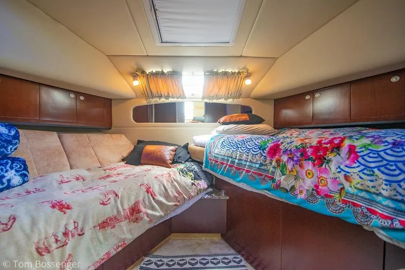 Slide: The Image of 2005 Sea Ray 390 Motor Yacht interior with cozy twin beds and vibrant bedding. - 34