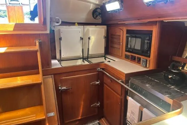 Slide: The Image of Compact wooden yacht kitchen interior with stove, microwave, and storage, Sabre 452, 2002 model. - 21
