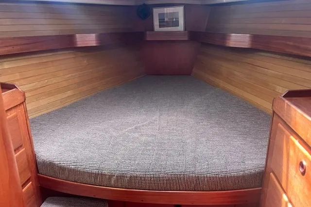 Slide: The Image of Cozy cabin interior of 2002 Sabre 452 boat with wooden paneling and cushioned bed. - 31