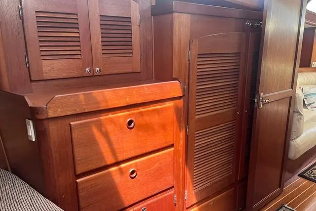 Slide: The Image of Wooden interior of 2002 Sabre 452 yacht, featuring cabinets and drawers with warm lighting. - 34