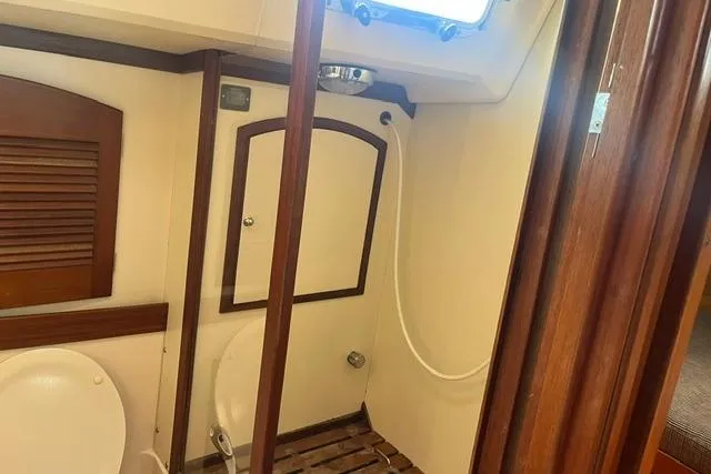 Slide: The Image of 2002 Sabre 452 yacht bathroom with wooden accents and compact design. - 37
