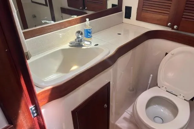Slide: The Image of 2002 Sabre 452 yacht bathroom with sink, mirror, and toilet. - 38