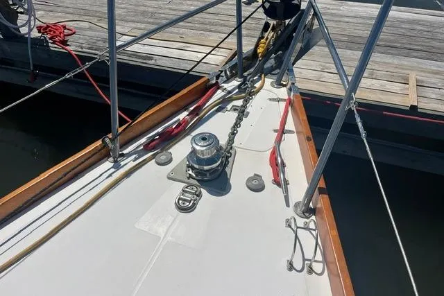Slide: The Image of Bow of a 2002 Sabre 452 sailboat docked, featuring anchor chain and winch. - 49
