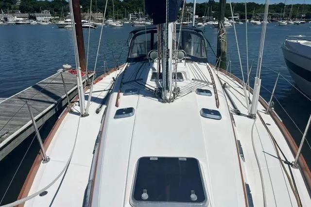 Slide: The Image of 2002 Sabre 452 sailboat docked in a marina, showcasing its sleek deck design. - 51