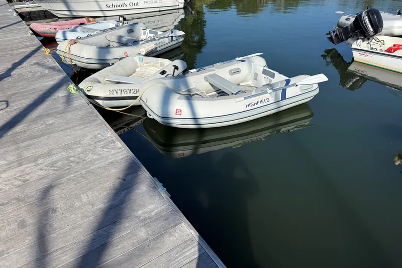Slide: The Image of Docked inflatable boats on calm water, featuring a 2002 Sabre 452 model. - 58