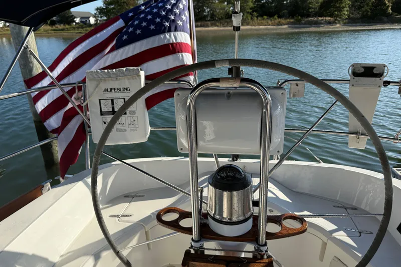 Slide: The Image of Steering wheel of 2002 Sabre 452 sailboat with American flag in background. - 59