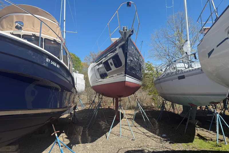 Slide: The Image of Three sailboats, including a 2002 Sabre 452, on stands in a boatyard. - 60