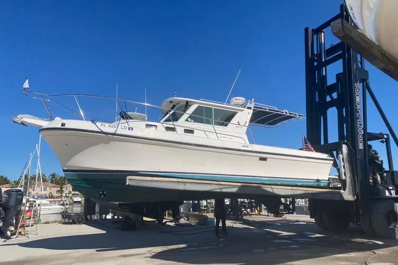 Slide: The Image of 2000 Albin 28 Tournament Express boat lifted by forklift at marina. - 1