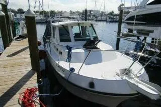 Slide: The Image of 2000 Albin 28 Tournament Express docked at a marina, surrounded by other boats. - 2